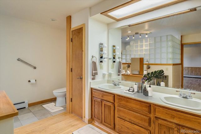 a bathroom with a double vanity sink mirror and toilet