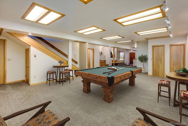 a living room with furniture a table and kitchen view