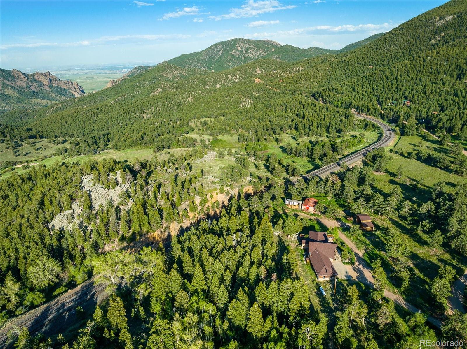 283 Chute Road Golden, CO 80403 - Photo 36 of 40 a view of a lush green forest with a lush green hillside