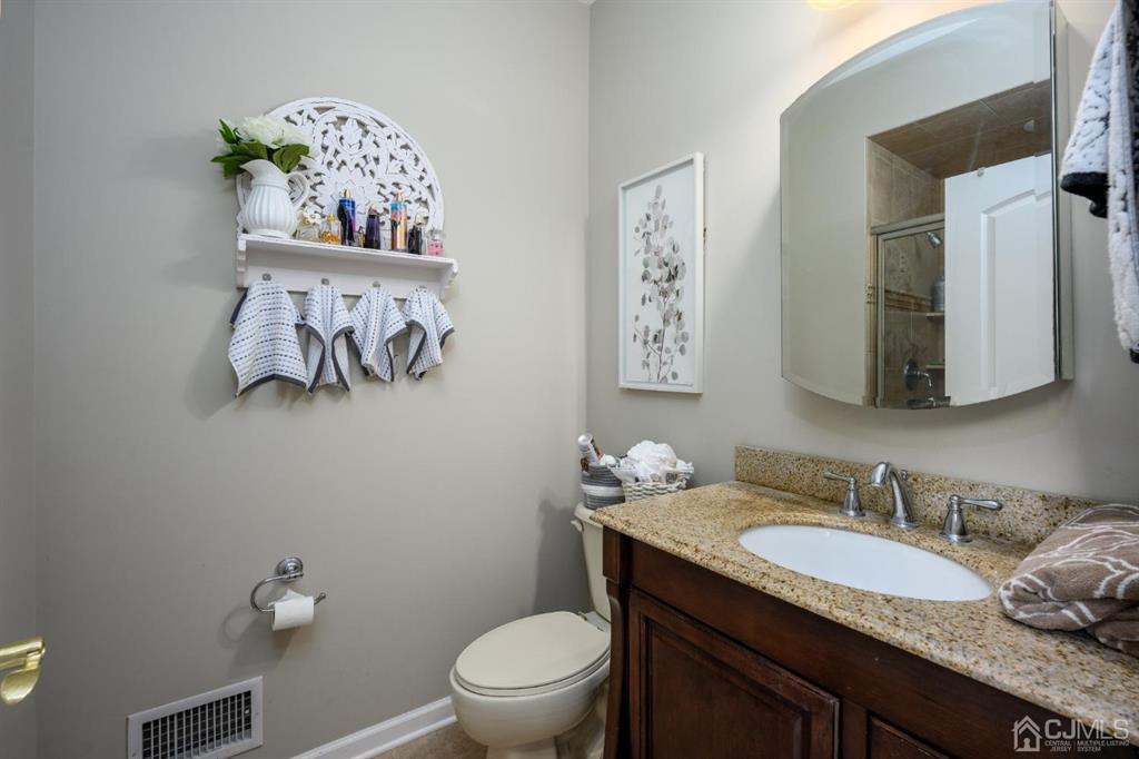 133 Thomas Drive Clark, NJ 07066 - Photo 18 of 30 a bathroom with a granite countertop toilet sink and mirror
