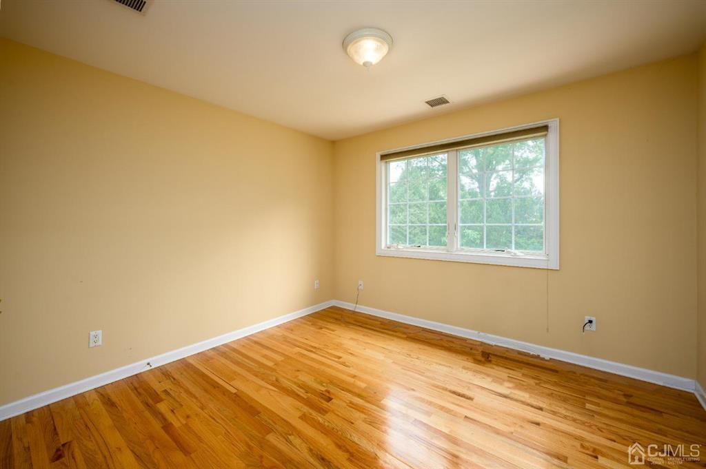 133 Thomas Drive Clark, NJ 07066 - Photo 23 of 30 a view of empty room with wooden floor and fan