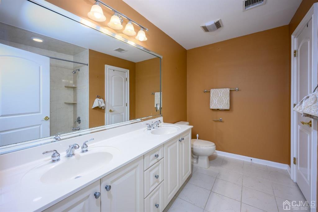 133 Thomas Drive Clark, NJ 07066 - Photo 25 of 30 a spacious bathroom with a double vanity sink a mirror and a toilet