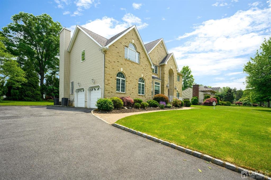 133 Thomas Drive Clark, NJ 07066 - Photo 3 of 30 a view of a white house next to a yard with big trees