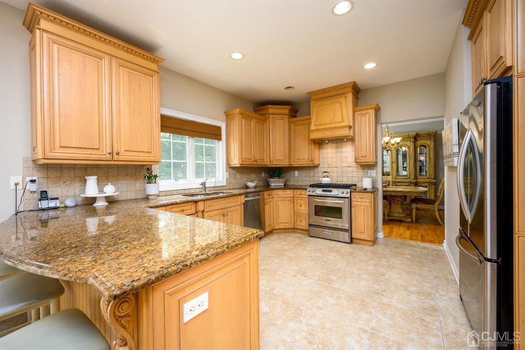 133 Thomas Drive Clark, NJ 07066 - Photo 10 of 30 a kitchen with stainless steel appliances granite countertop a stove a sink and a refrigerator