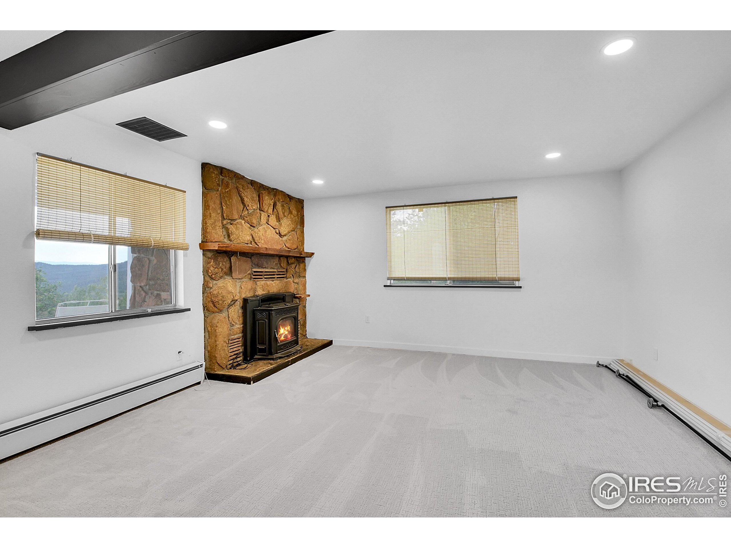 24927 Agate Avenue Conifer, CO 80433 - Photo 19 of 33 a view of an empty room with a fireplace and a window