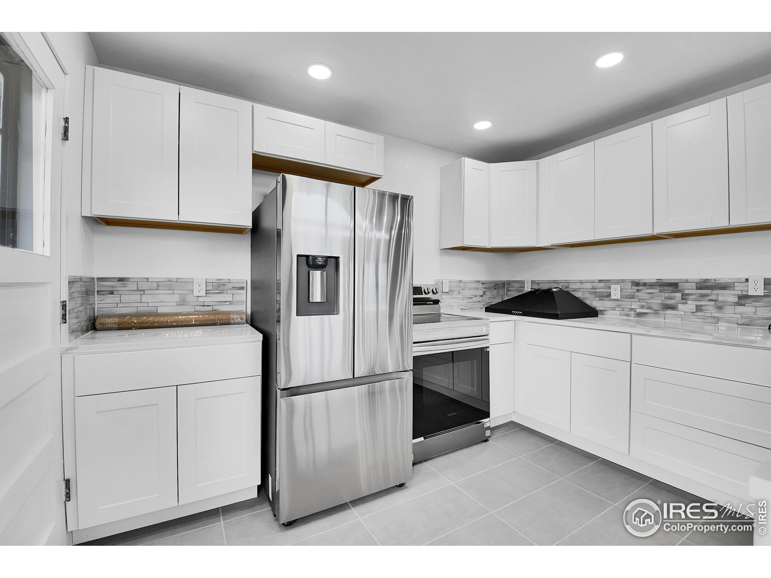 24927 Agate Avenue Conifer, CO 80433 - Photo 26 of 33 a kitchen with white cabinets and stainless steel appliances
