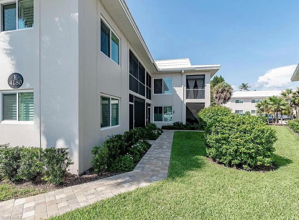 4180 Crayton Road, Unit E8 Naples, FL 34103 - Photo 16 of 20 a front view of a house with garden