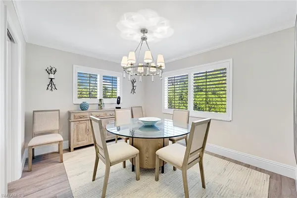 a dining room with furniture a chandelier and wooden floor