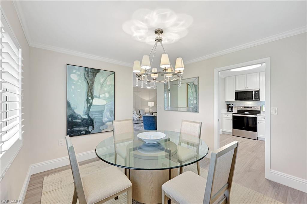 4180 Crayton Road, Unit E8 Naples, FL 34103 - Photo 4 of 20 a view of a dining room with furniture and wooden floor