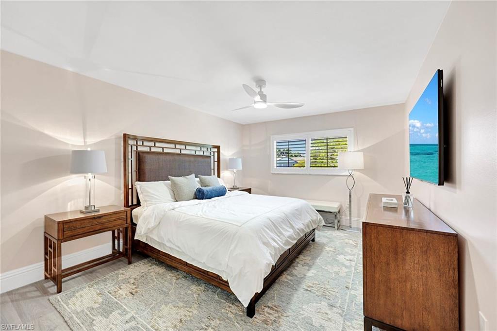 4180 Crayton Road, Unit E8 Naples, FL 34103 - Photo 6 of 20 a bedroom with a bed lamp and a dresser