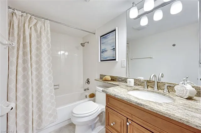 a bathroom with a granite countertop sink a toilet and a mirror