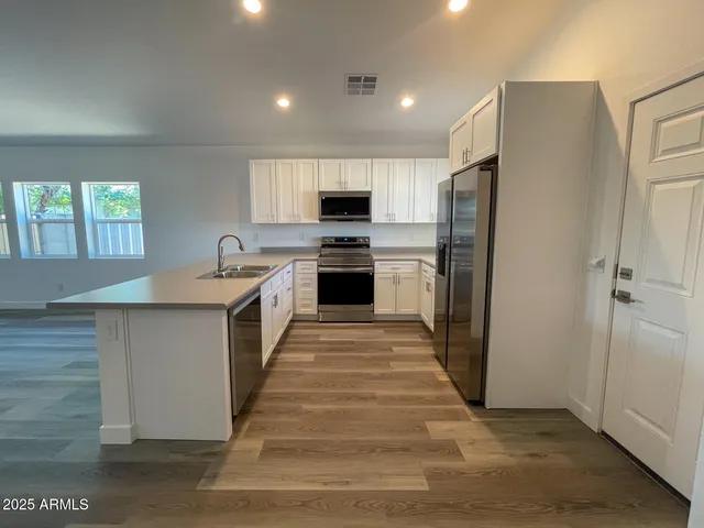a large kitchen with a white stove top oven and refrigerator