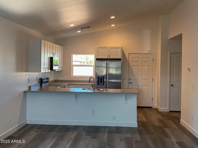 a kitchen with a sink cabinets and wooden floor