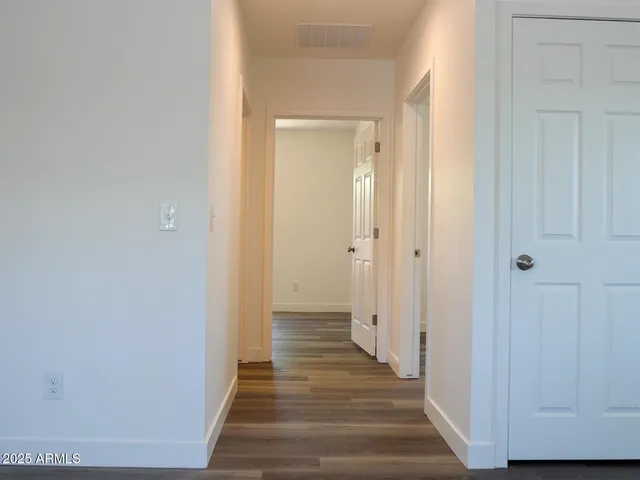 a view of a hallway with wooden floor and staircase