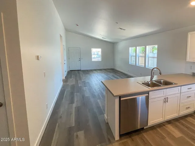 a kitchen with a sink and wooden floor
