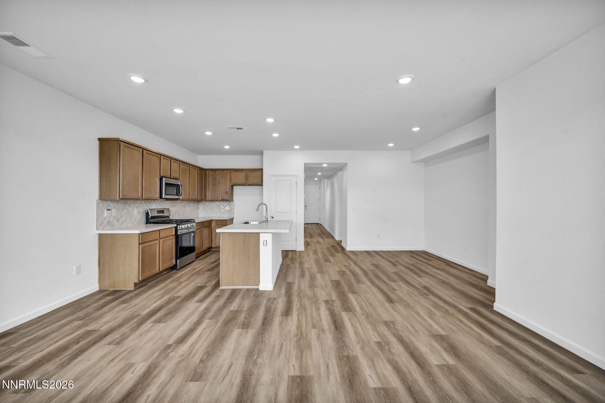 6676 Morgan Mill Road, Unit HOMESITE 14 Carson City, NV 89701 - Photo 6 of 24 a large kitchen with a center island wooden floor stainless steel appliances and cabinets
