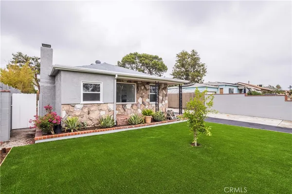 a front view of a house with a garden and plants