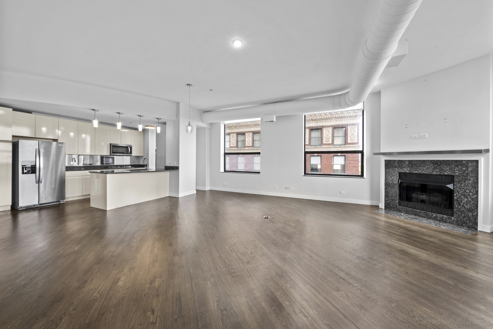 910 South Michigan Avenue, Unit 1004 Chicago, IL 60605 - Photo 11 of 22 a view of an empty room with a kitchen and fireplace