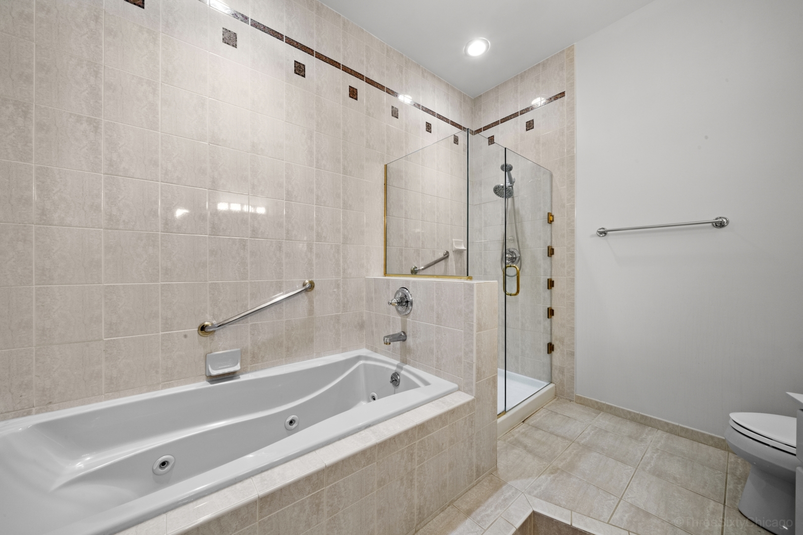 910 South Michigan Avenue, Unit 1004 Chicago, IL 60605 - Photo 14 of 22 a bathroom with a tub a toilet and a shower