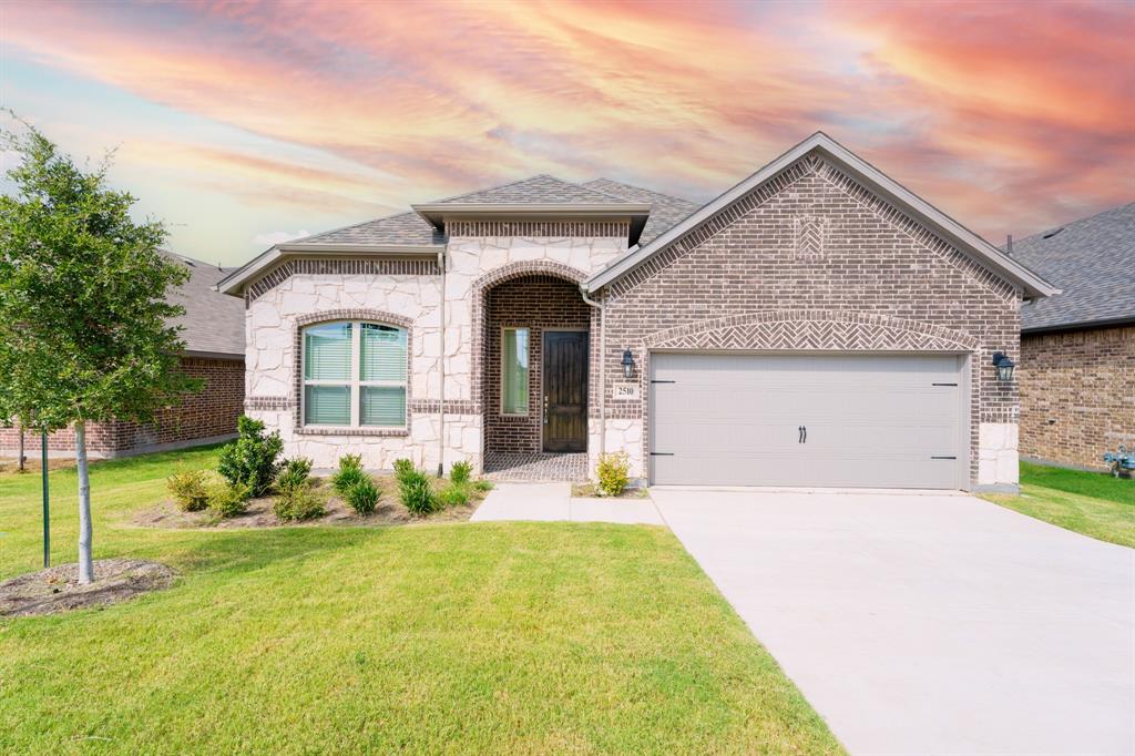 a front view of a house with a yard and garage