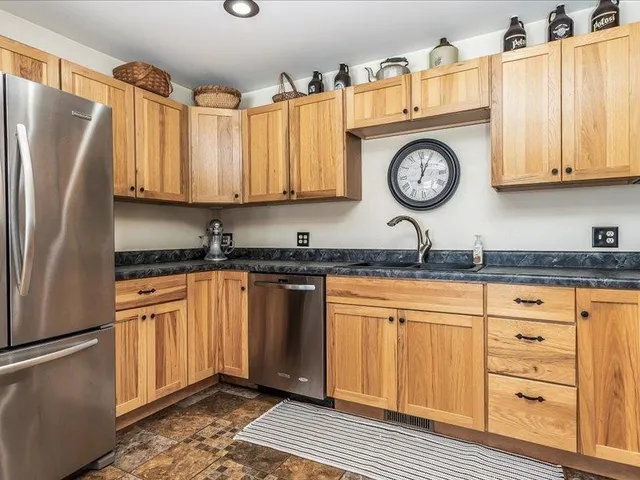 a kitchen with stainless steel appliances granite countertop a refrigerator and a stove top oven