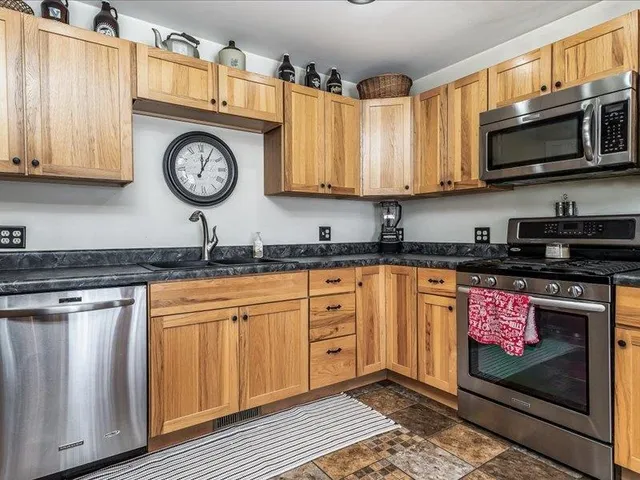 a kitchen with stainless steel appliances granite countertop a sink and cabinets