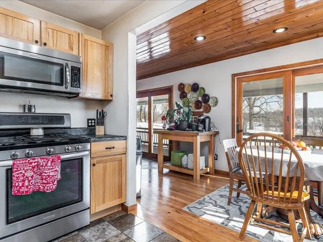 a kitchen with stainless steel appliances granite countertop a stove a sink dishwasher and a microwave with wooden floor