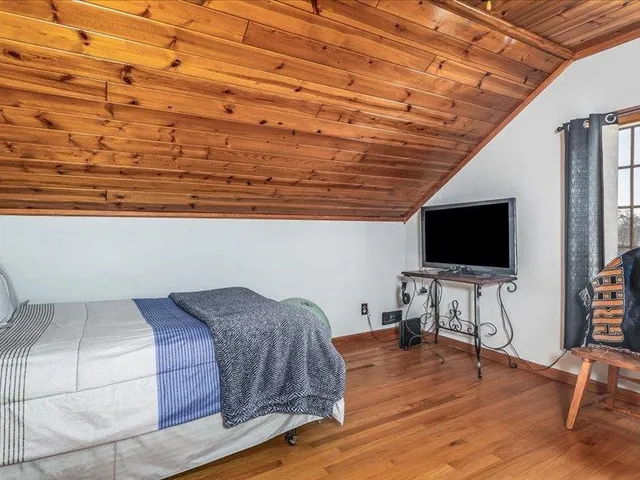 a living room with a bed furniture and a flat screen tv