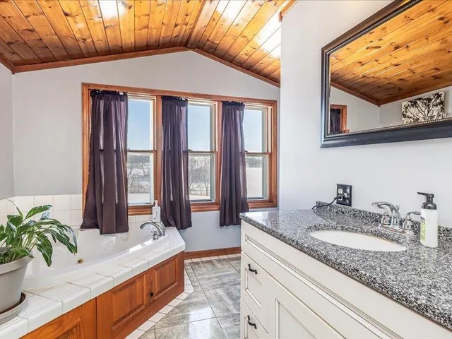 a bathroom with a granite countertop sink and a large mirror