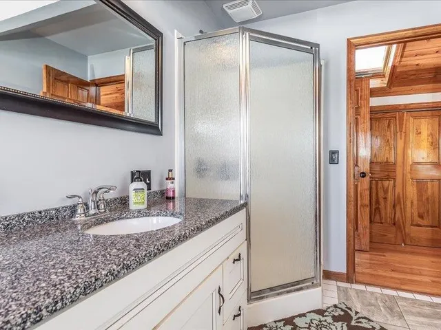 a bathroom with a granite countertop sink and a mirror
