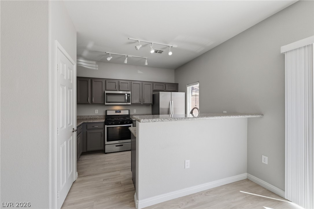 6312 Sandy Ridge Street, Unit 3102 North Las Vegas, NV 89081 - Photo 6 of 31 A contemporary kitchen showcases sleek stainless steel appliances and light-toned flooring.