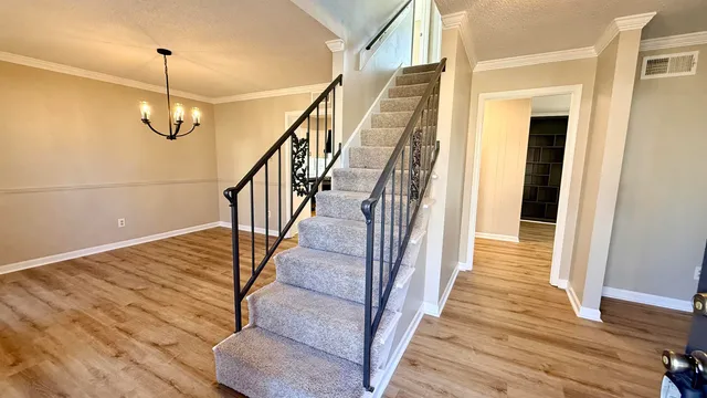 a view of a hallway with wooden floor and stairs