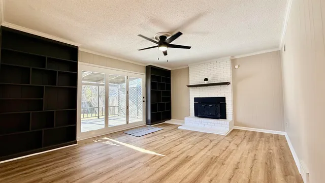 a view of a livingroom with wooden floor a ceiling fan and a bathroom