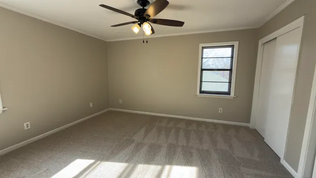 an empty room with windows and fan