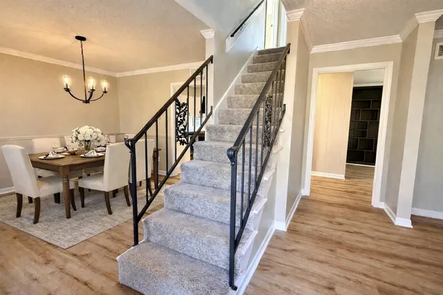 a view of a hallway with wooden floor and staircase