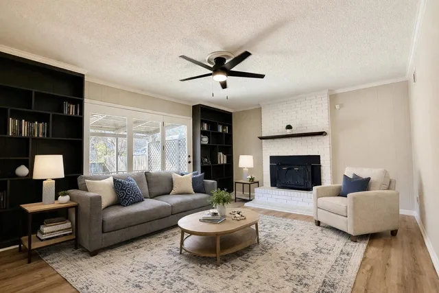 a living room with furniture a fireplace and a flat screen tv