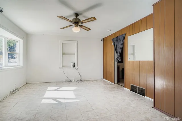 an empty room with fan and windows