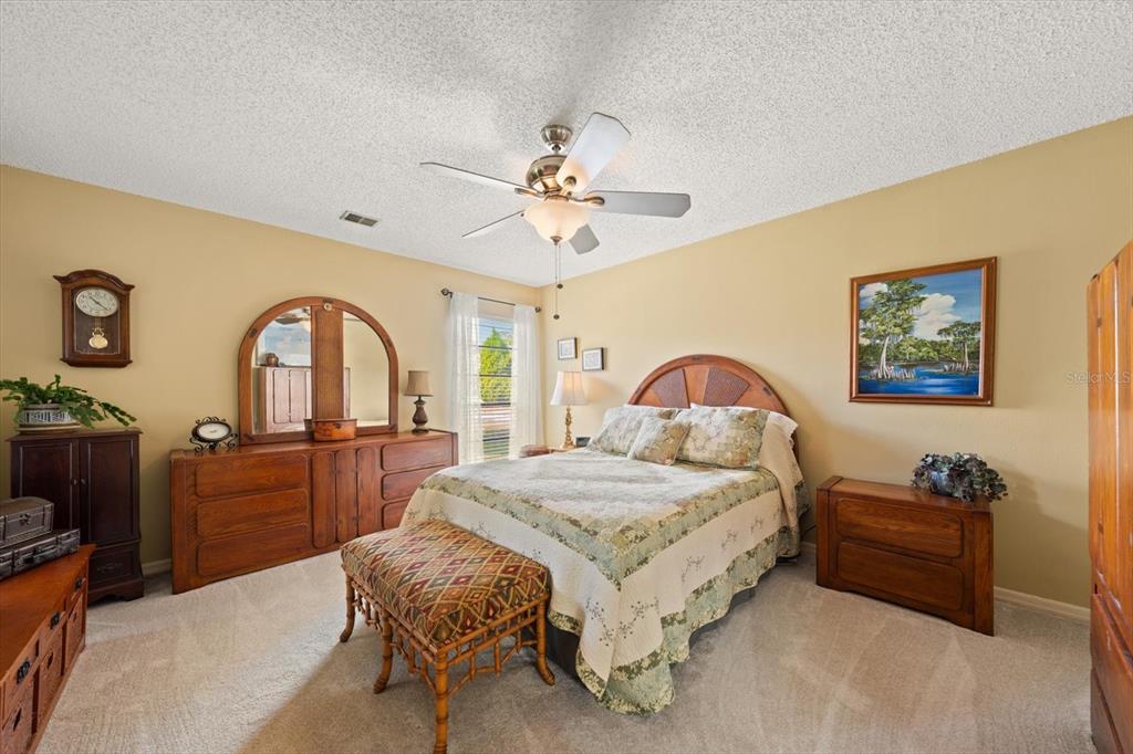 1801 East Lake Road South, Unit 10D Palm Harbor, FL 34685 - Photo 12 of 27 a bedroom with a bed and a dresser