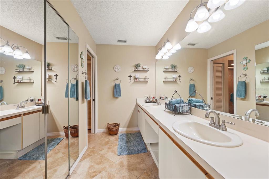 1801 East Lake Road South, Unit 10D Palm Harbor, FL 34685 - Photo 14 of 27 a spacious bathroom with a sink double vanity granite tub shower and mirror