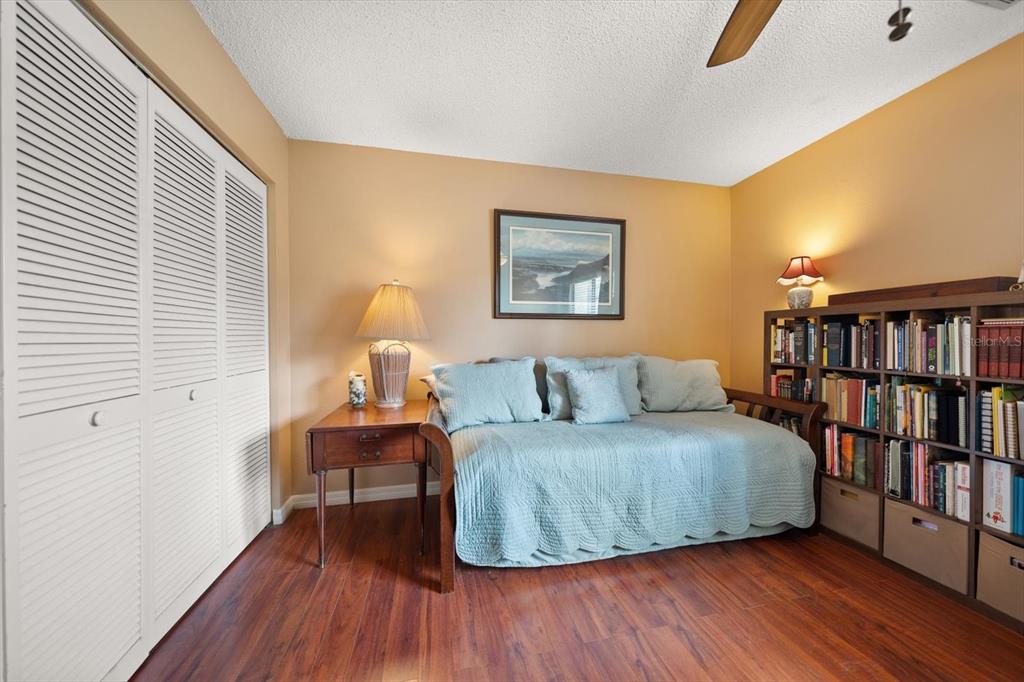 1801 East Lake Road South, Unit 10D Palm Harbor, FL 34685 - Photo 17 of 27 a bedroom with a bed and a book shelf