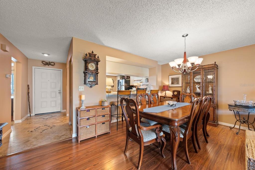 1801 East Lake Road South, Unit 10D Palm Harbor, FL 34685 - Photo 8 of 27 a view of a dining room with furniture and wooden floor
