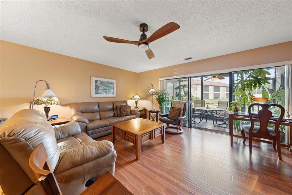1801 East Lake Road South, Unit 10D Palm Harbor, FL 34685 - Photo 9 of 27 a living room with furniture floor to ceiling window and wooden floor