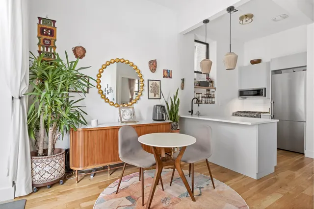a dining room with furniture and a potted plant