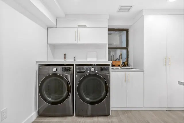 a utility room with sink dryer and washer