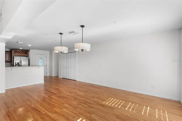 a view of an empty room with window and wooden floor