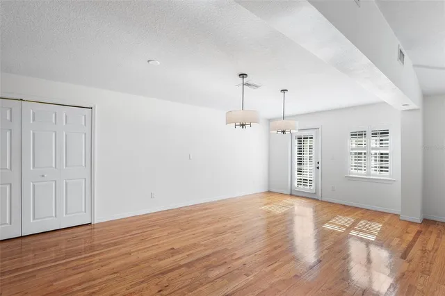 a view of empty room with kitchen and window