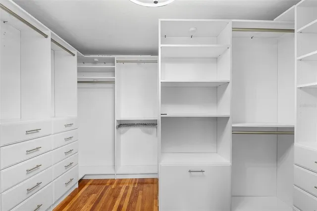 a view of walk in closet with empty racks