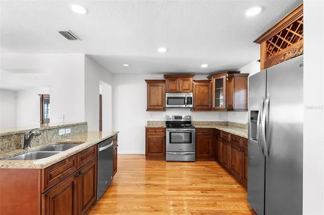 a kitchen with stainless steel appliances granite countertop a refrigerator and a stove top oven