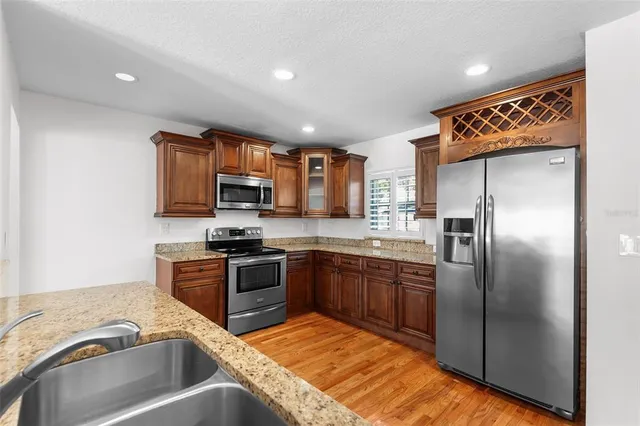 a kitchen with stainless steel appliances granite countertop a sink stove and refrigerator