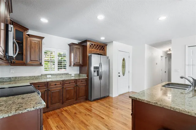 a kitchen with a stove and wooden floor